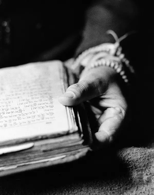Black and white photo by Roy Zipstein: a hand with a book