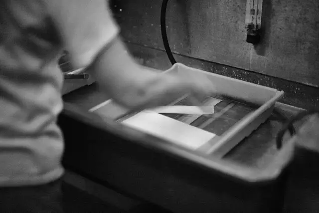 Developing prints in a chemical bath.  Photo by PHOTOarts/Magazine.