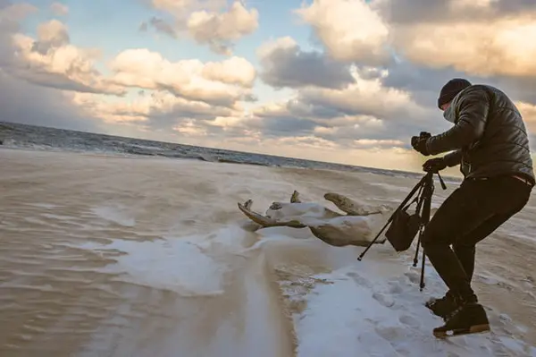 man photographing ocean