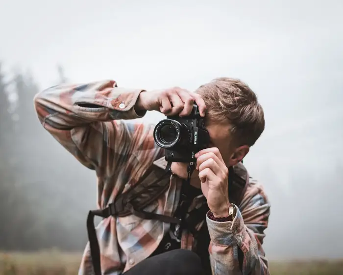 Man taking photo with camera on strap
