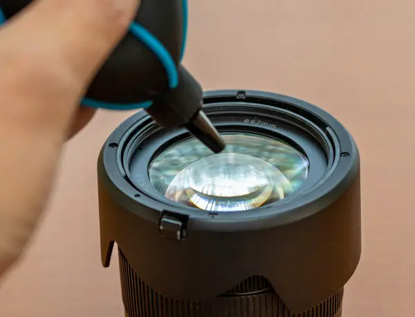 blower being used on a lens
